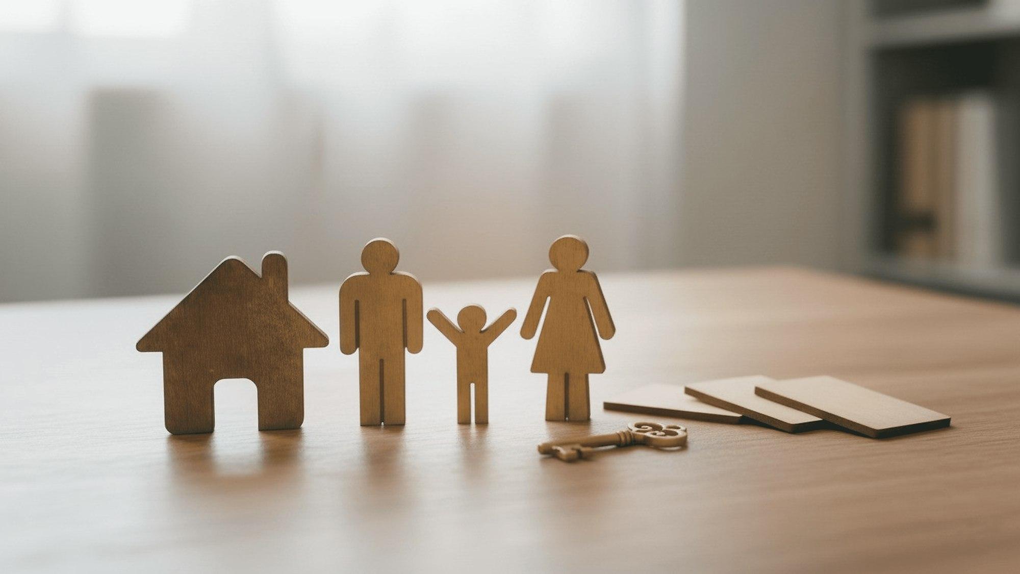House keys and family figurines on a table, representing a home purchase decision