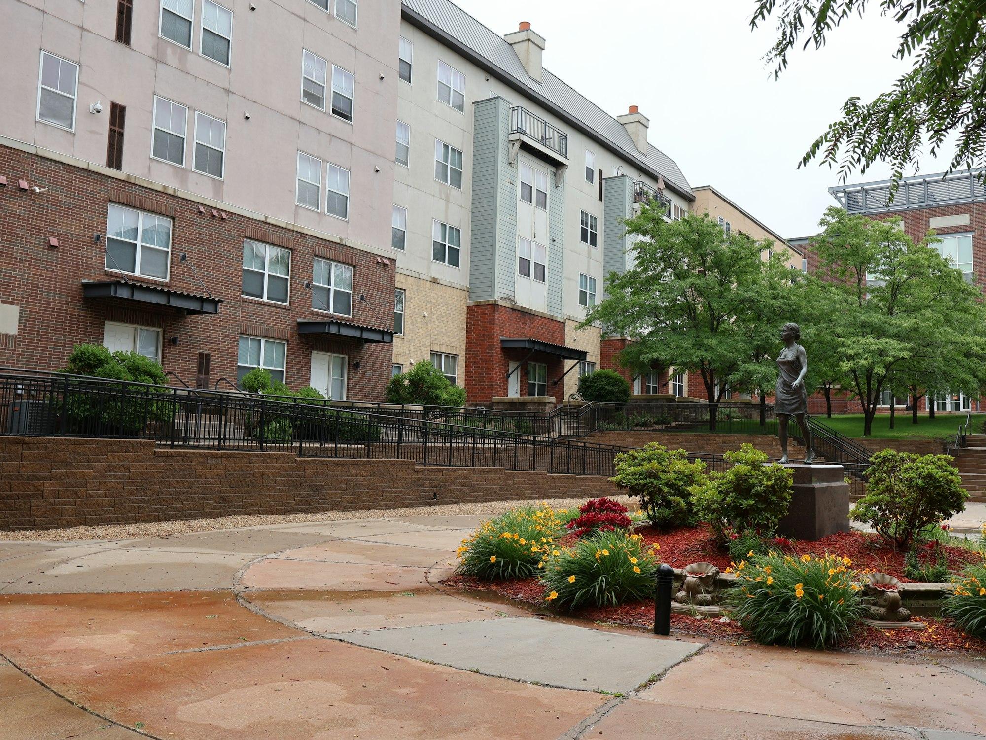 Landscaped residential courtyard with mature trees, water feature and shaded walkways