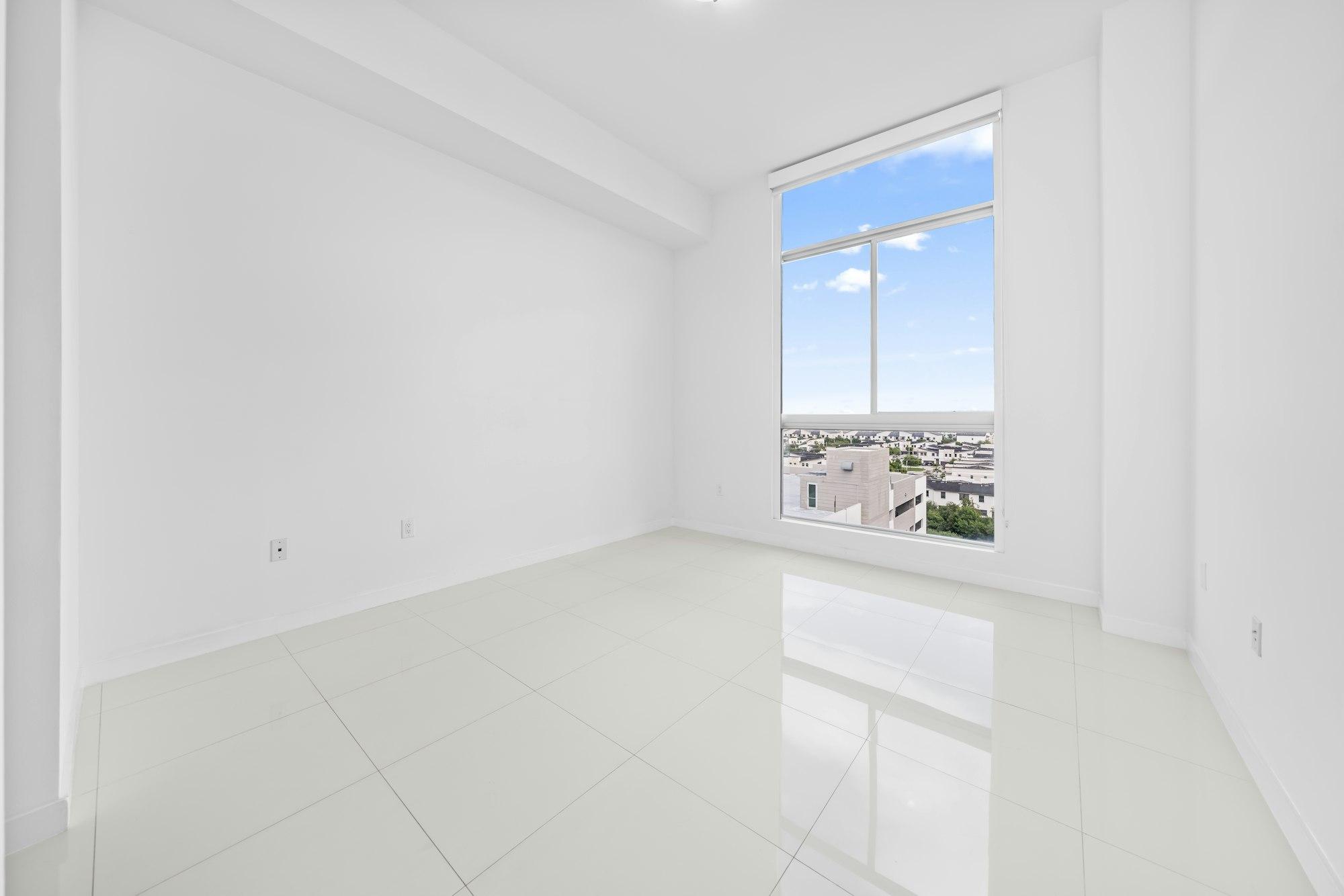 Naturally lit living room of a large-format luxury apartment with a full-height city-view window